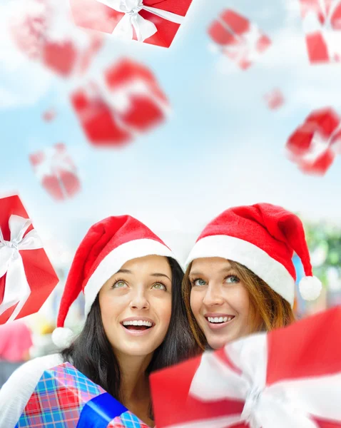 Junge glückliche Mädchen mit Weihnachtsmützen. Zusammenstehen drinnen — Stockfoto