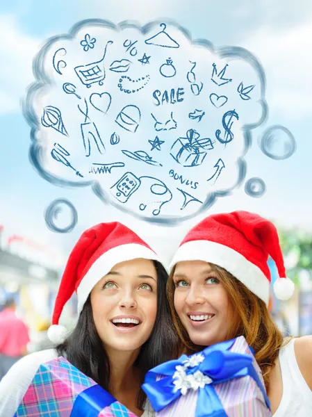 Молоді щасливі дівчата в різдвяних капелюхах. Стоячи разом у приміщенні , — стокове фото