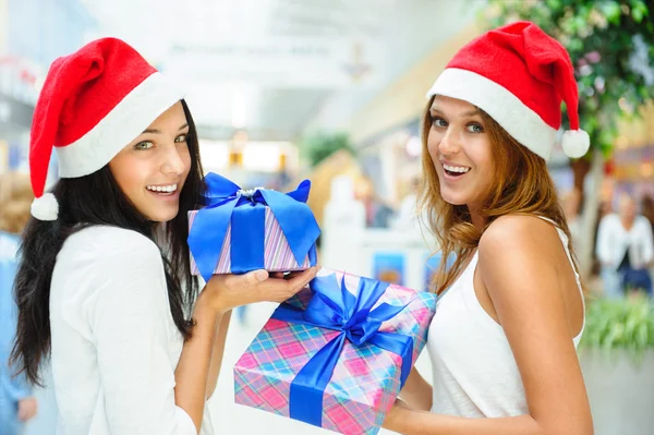 Unga glada tjejer i jul hats.standing tillsammans inomhus, — Stockfoto