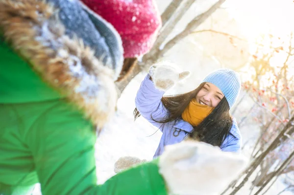 Zwei glückliche junge Mädchen, die Spaß im Winterpark haben und Schnee spielen — Stockfoto