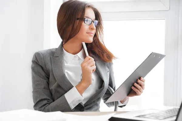 Hermosa mujer de negocios mirando los papeles que sostiene en su ar — Foto de Stock