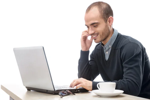 Um jovem sentado na frente de um laptop isolado — Fotografia de Stock