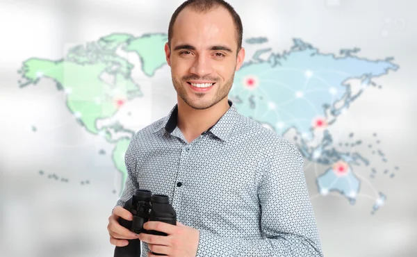 Homem adulto segurando binóculos contra mapa do mundo. À procura de pessoal de escritório profissional — Fotografia de Stock