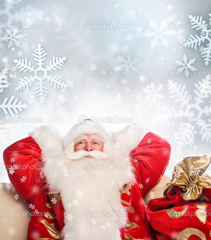 Santa Claus sitting with a sack indoor relaxing on silwer snowfl
