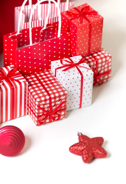 Gift boxes with xmas presents wrapped in red paper with ornament — Stock Photo, Image