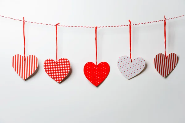 Vermelho corações texturizados pendurados no fundo branco — Fotografia de Stock