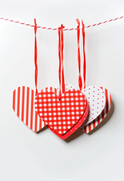 Red textured hearts hanging on white background — Stock Photo, Image