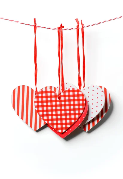 Röda texturerat hjärtan som hänger på vit bakgrund — Stockfoto