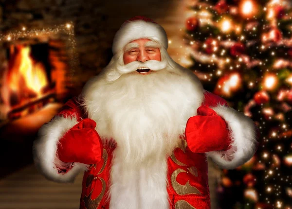Śmiejąc się Mikołaj stoi w domu w pobliżu kominek i christm — Zdjęcie stockowe