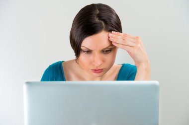 düşünme, el ile dizüstü bilgisayar üzerinde çalışan genç üzücü ciddi kadın