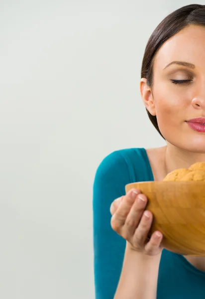 Hermosa mujer sosteniendo caliente fresco olor galletas de avena con clos —  Fotos de Stock