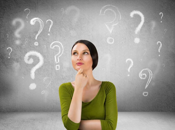 Beautiful woman with questioning expression and question marks a — Stock Photo, Image