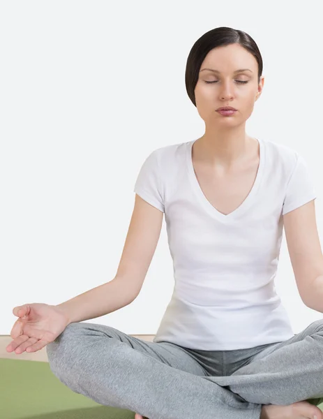 Retrato de una mujer joven y bonita haciendo ejercicio de yoga en la esterilla —  Fotos de Stock