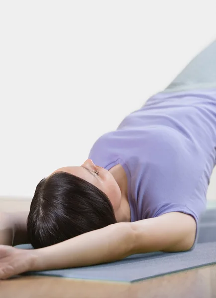 Portrait of healthy young woman practising yoga exercise on mat — Stock Photo, Image