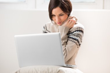 onu laptop önünde oturan genç bir kadın