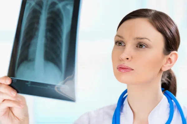 Médico femenino mirando una radiografía de pulmones o torso, fluorografía —  Fotos de Stock