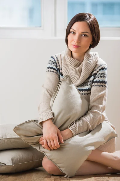 Portret van een mooie brunette vrouw zittend op de vloer — Stockfoto