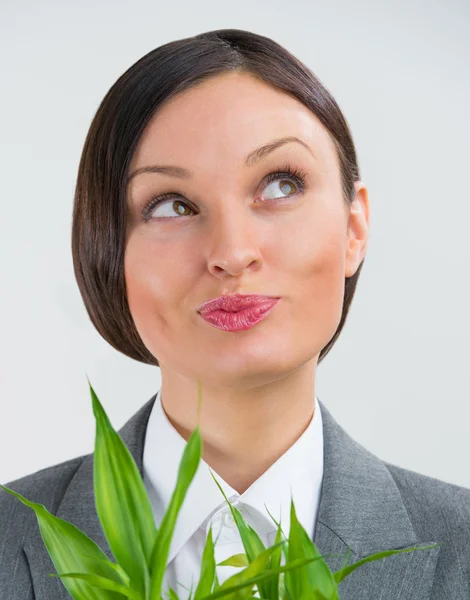 Adulto donna d'affari guardando in alto e tenendo piante di bambù fortunato s — Foto Stock