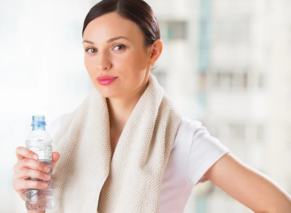 Portret van vertrouwen jonge vrouw in sportkleding bedrijf een water — Stockfoto