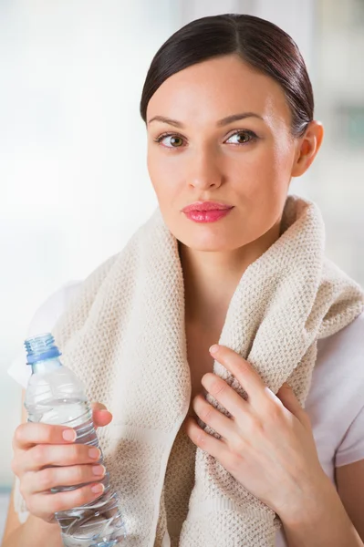 Portret van vertrouwen jonge vrouw in sportkleding bedrijf een water — Stockfoto