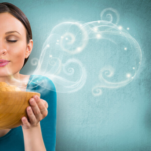 Young pretty housewife holding hot tasty cookies in wooden dish.