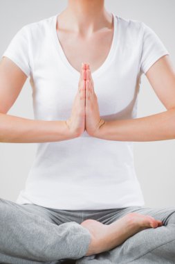 meditasyon sırasında lotus pozisyonda oturan genç bir kadın