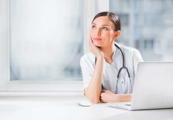 Porträt einer Ärztin, die ihren Laptop in der Klinik benutzt — Stockfoto