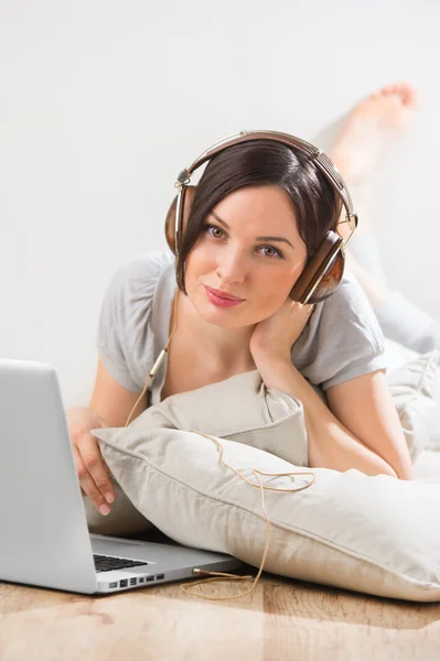 A young woman laying on the floor in front of her laptop — Stock Photo, Image