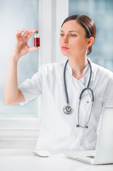 Retrato de una guapa asistente de laboratorio analizando una sangre — Foto de Stock