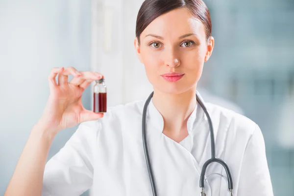 Retrato de una guapa asistente de laboratorio analizando una sangre — Foto de Stock