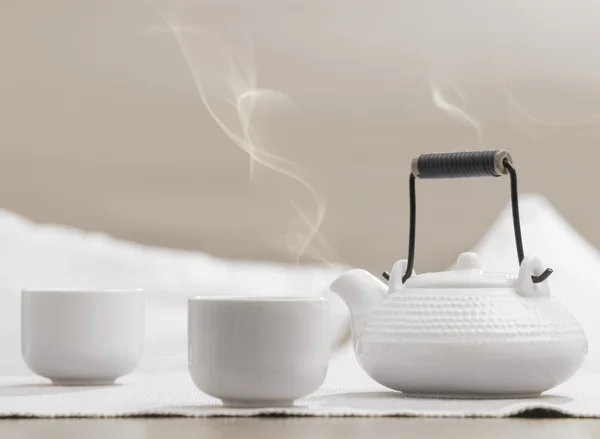 Théière et tasses sur la table dans un salon de relaxation confortable — Photo