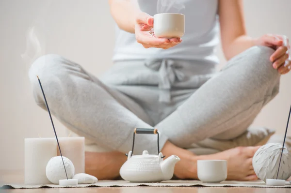 Mujer sentada en el suelo de su casa y sosteniendo la taza de té — Foto de Stock