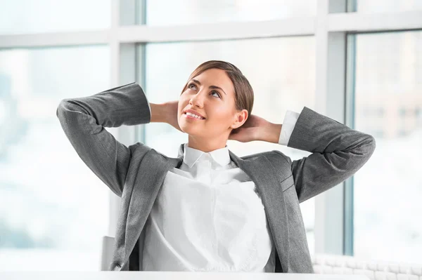 Retrato de sorridente jovem empresária relaxante no escritório — Fotografia de Stock