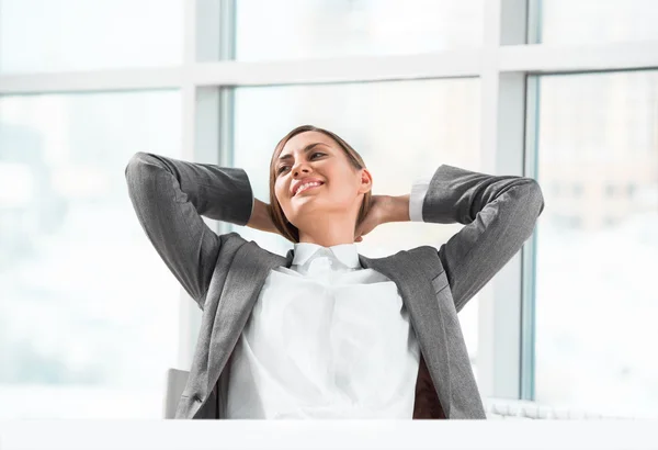Portrait of smiling young business woman relaxing at office — Stock Photo, Image