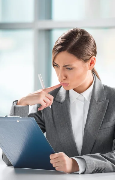 Front view of business woman looking over papers on clipboard at — Stock Photo, Image