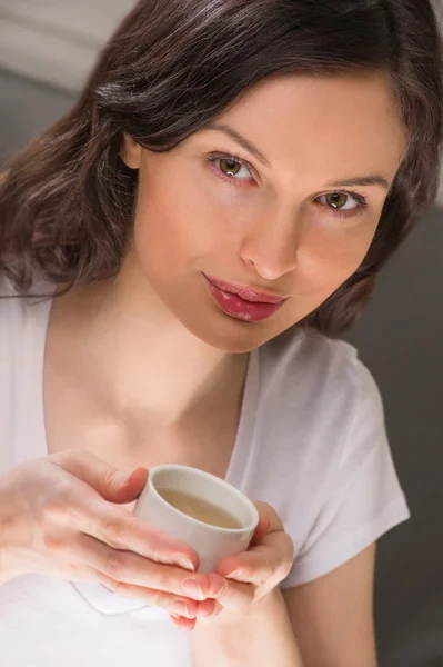 Macro vista de una hermosa mujer joven sosteniendo una taza de té o co —  Fotos de Stock