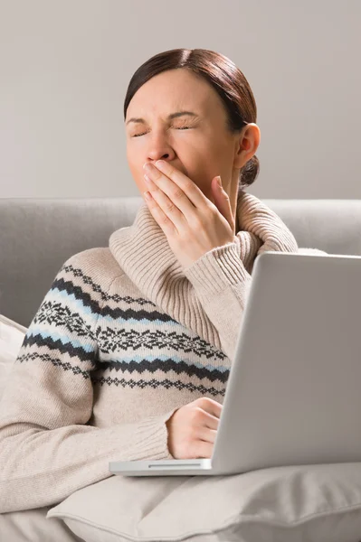 Porträt einer jungen Frau, die vor ihrem Laptop auf dem Sofa sitzt — Stockfoto