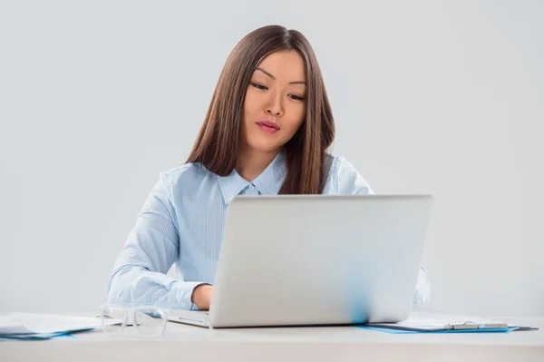 Portræt af en smilende smuk ung forretningskvinde, der arbejder på laptop - Stock-foto