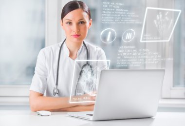 Yüksek teknolojili bilgisayar ekranlı doktor hasta verilerini izliyor