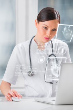 Yüksek teknolojili bilgisayar ekranlı doktor hasta verilerini izliyor