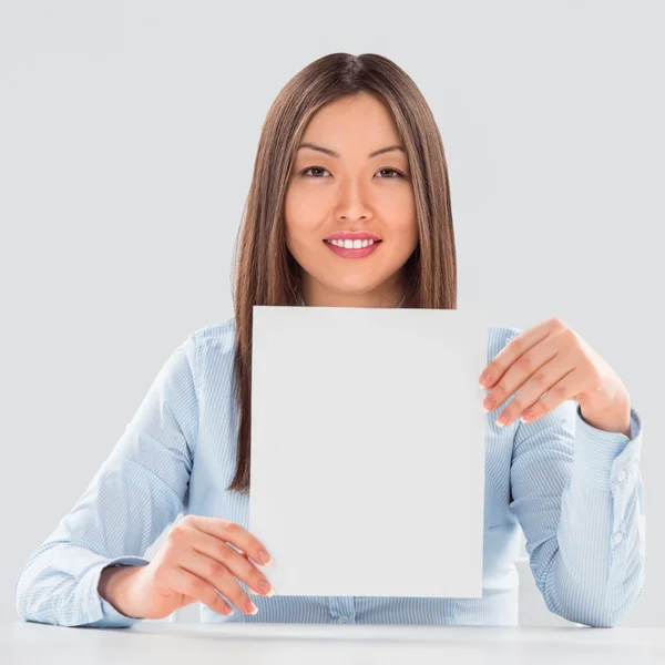 Portrait of business woman with blank sheet over gray background — Stock Photo, Image