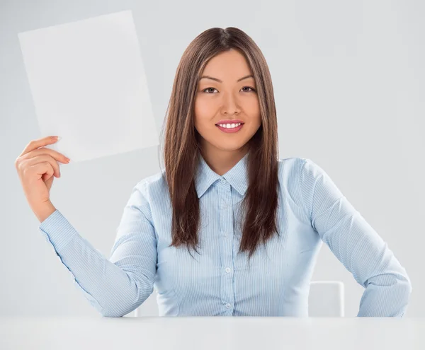 Portrait de femme d'affaires avec feuille vierge sur fond gris — Photo