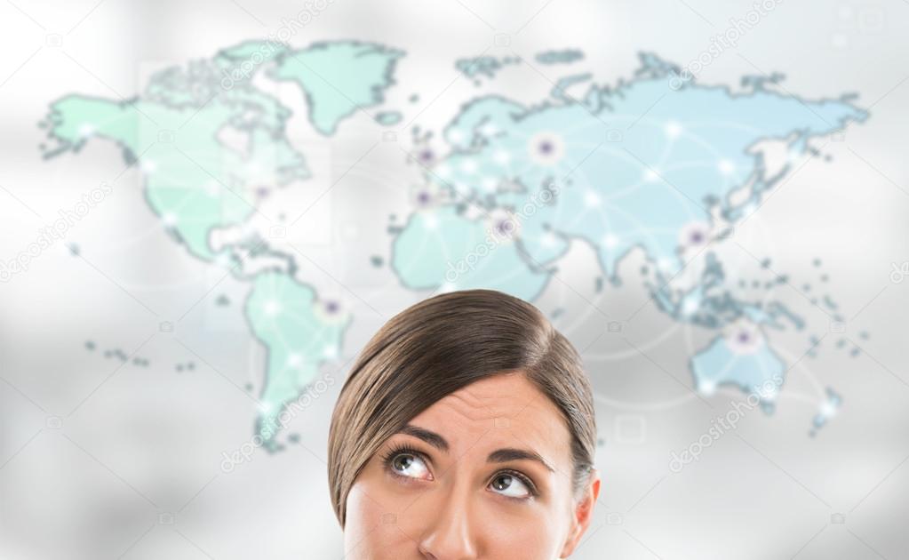 Portrait of young woman standing in front of big world map.