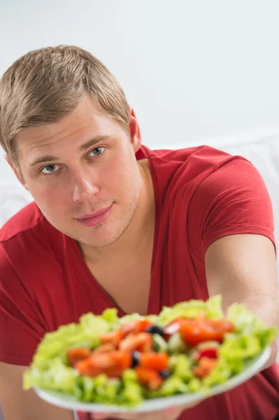 Mladý pohledný muž přípravu sníst čerstvý zdravý salát — Stock fotografie