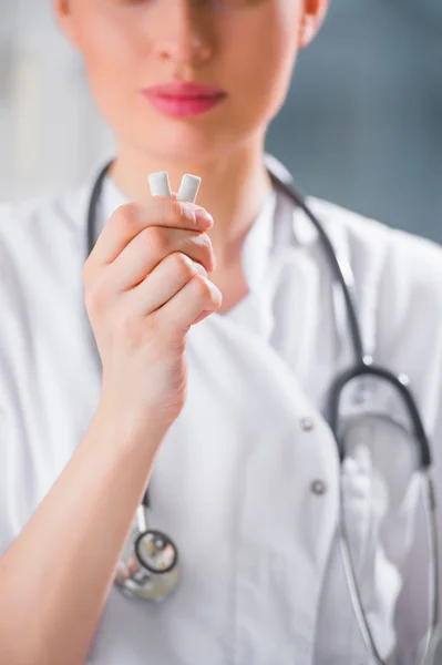 Joven dentista doctora sosteniendo goma de mascar y sonriendo . —  Fotos de Stock