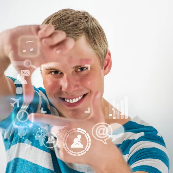 Homem bonito jovem usando interface virtual com muitos ícones da web e das mídias sociais — Fotografia de Stock