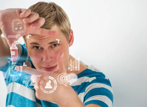 Young handsome man using virtual interface with lots of web and social media icons — Stock Photo, Image