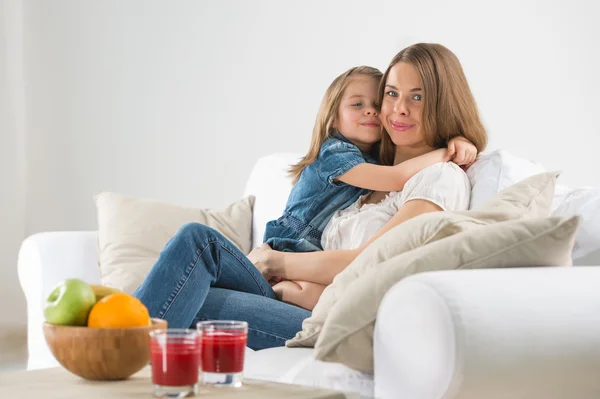 Portrait of adorable young girl and mother embracing at home — Stock Photo, Image