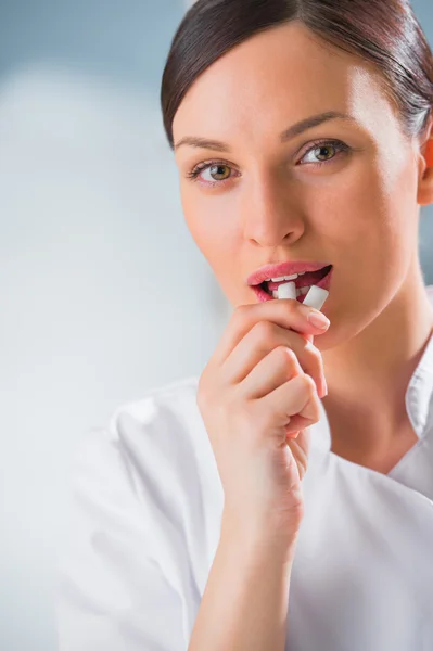 Jovem dentista feminina médico segurando chiclete e sorrindo . — Fotografia de Stock