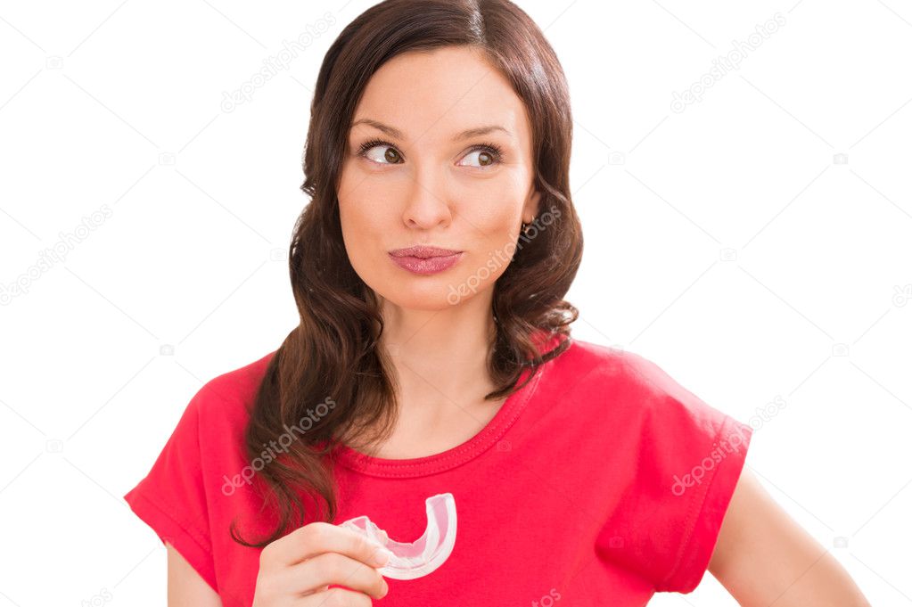 Woman wearing orthodontic braces holding silicone trainer